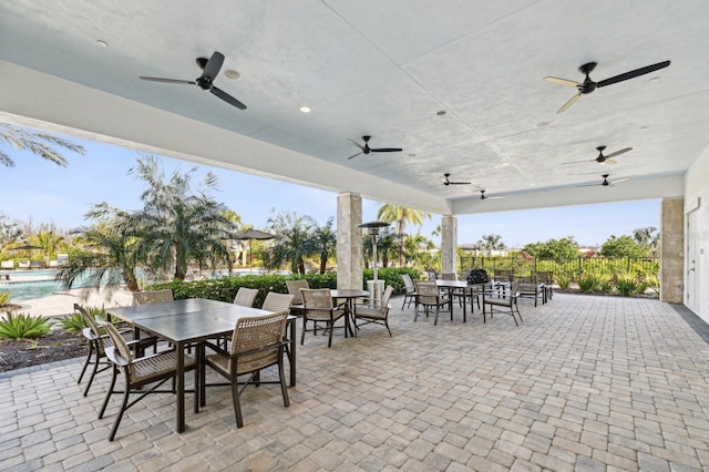 view of patio featuring a ceiling fan, outdoor dining area, and an outdoor pool