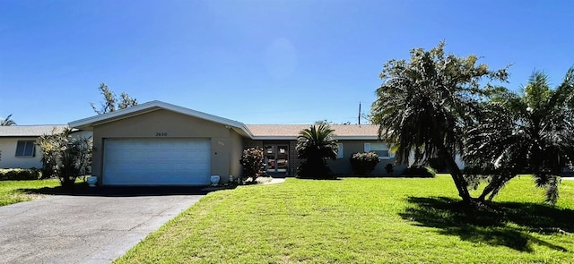 ranch-style house featuring a garage, aphalt driveway, a front lawn, and stucco siding