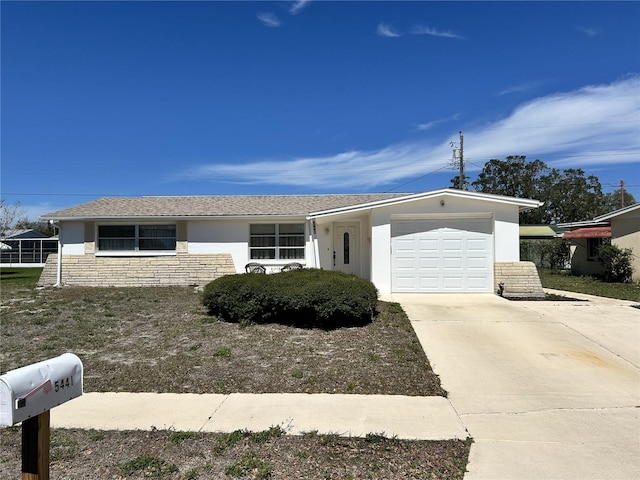 single story home with concrete driveway, stone siding, an attached garage, and stucco siding