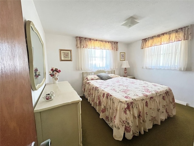 bedroom with dark carpet and baseboards