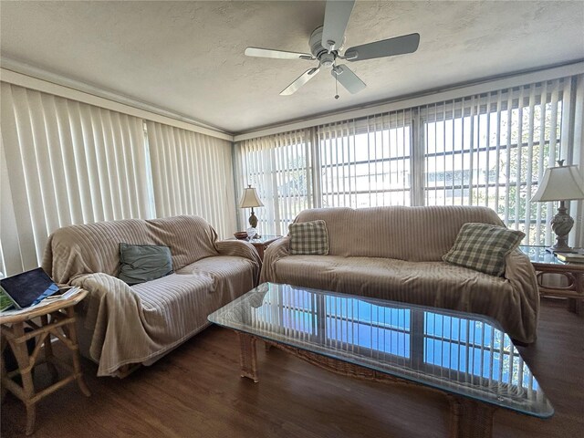 living room with a textured ceiling, ceiling fan, and wood finished floors