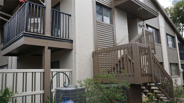 view of side of property featuring stairway and stucco siding