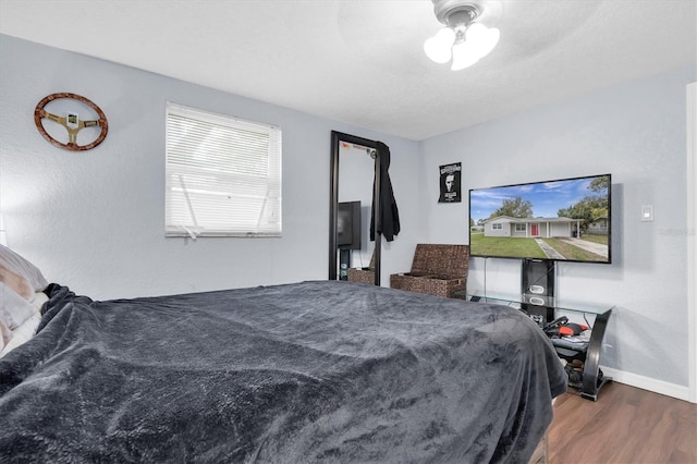 bedroom with baseboards and wood finished floors