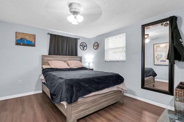 bedroom with a textured ceiling, a ceiling fan, baseboards, and wood finished floors