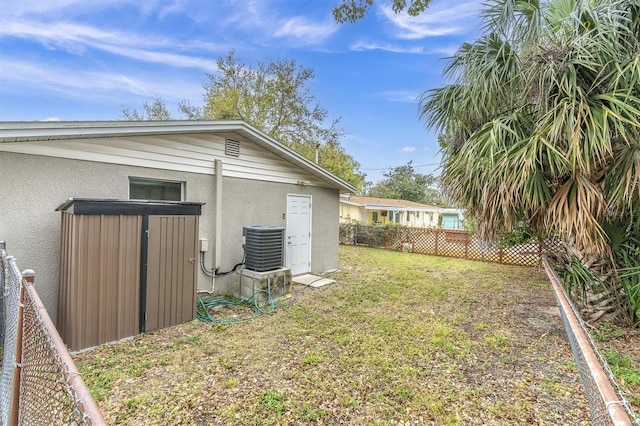 view of yard featuring central air condition unit and fence