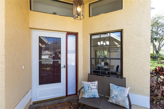 entrance to property featuring stucco siding