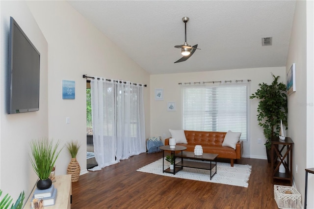 living area with visible vents, lofted ceiling, ceiling fan, wood finished floors, and a textured ceiling