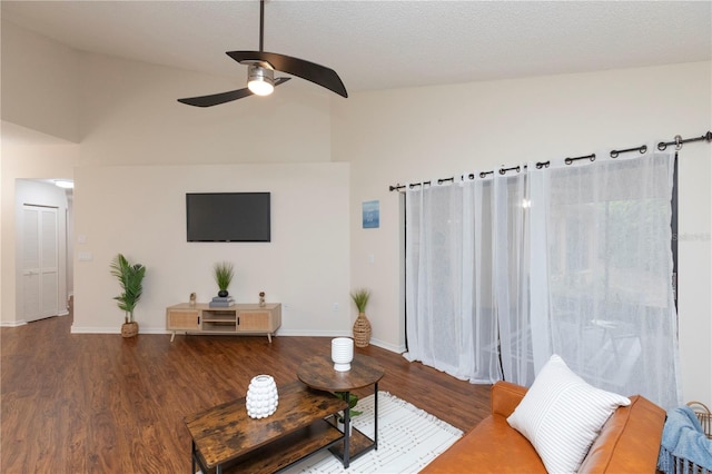 living area featuring lofted ceiling, ceiling fan, baseboards, and wood finished floors