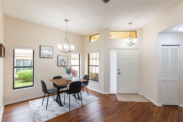 dining room with a chandelier, dark wood-style flooring, a wealth of natural light, and baseboards