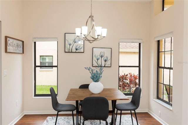 dining area featuring dark wood-style floors, a notable chandelier, and a wealth of natural light