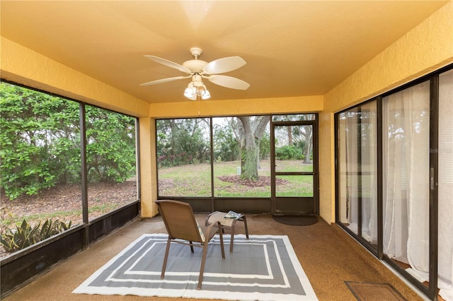 unfurnished sunroom with ceiling fan, visible vents, and a wealth of natural light