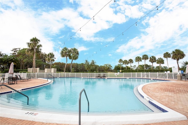 pool with fence and a patio