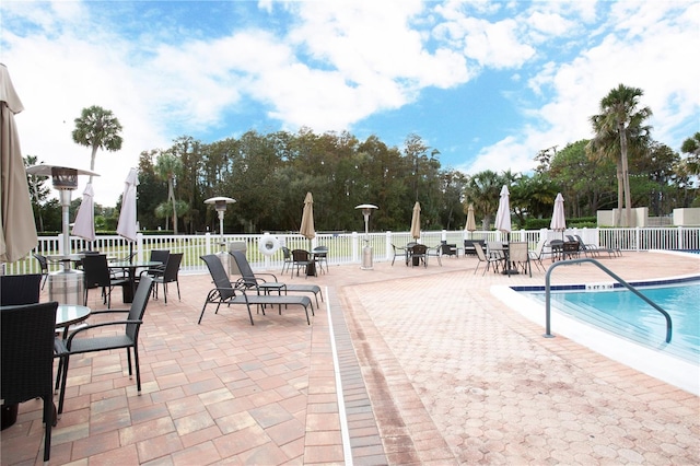 view of swimming pool with fence and a patio