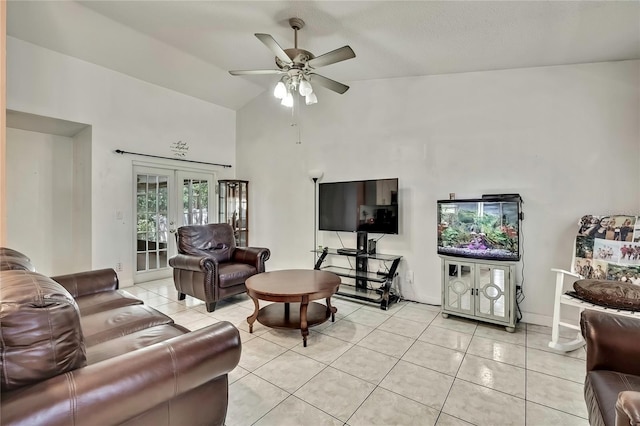 living area with light tile patterned floors, ceiling fan, high vaulted ceiling, baseboards, and french doors