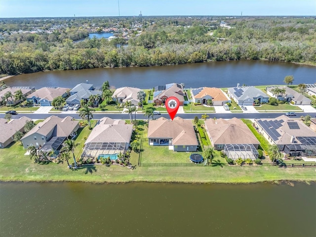 aerial view with a residential view, a wooded view, and a water view