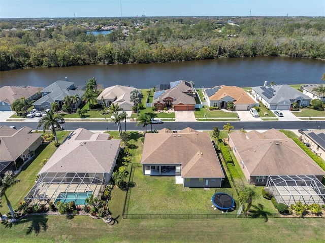 bird's eye view featuring a wooded view, a residential view, and a water view