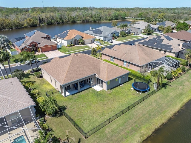 birds eye view of property with a residential view, a wooded view, and a water view