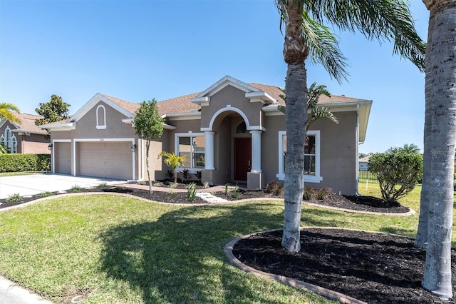 view of front facade featuring stucco siding, a front yard, concrete driveway, and an attached garage