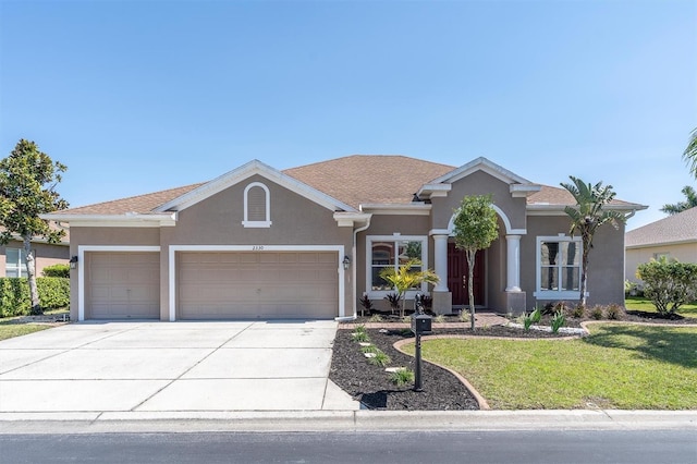 single story home with stucco siding, an attached garage, driveway, and a front yard