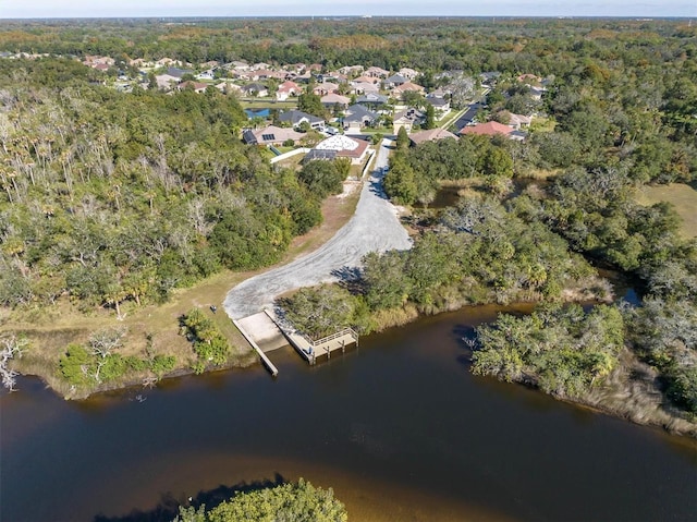 drone / aerial view with a wooded view and a water view