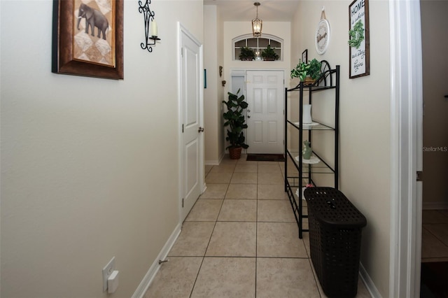 corridor with baseboards and light tile patterned flooring