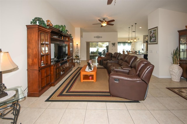 living area with ceiling fan, baseboards, and light tile patterned flooring