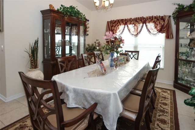 dining area featuring a healthy amount of sunlight, light tile patterned floors, baseboards, and a notable chandelier