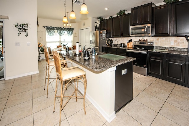 kitchen featuring stainless steel appliances, light tile patterned flooring, and tasteful backsplash