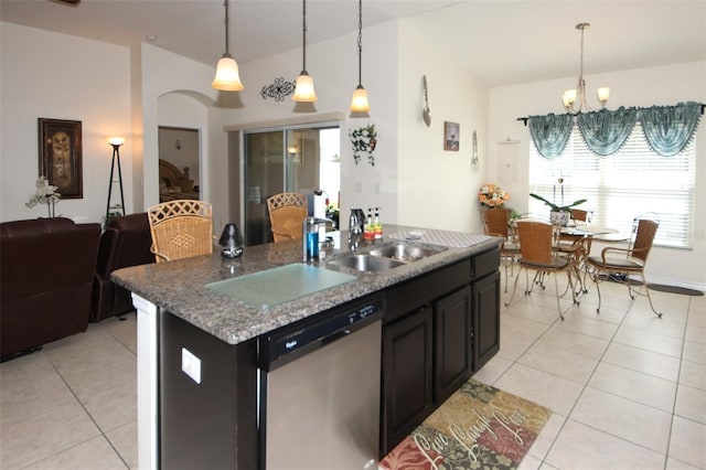 kitchen with light tile patterned floors, dishwasher, an island with sink, open floor plan, and a chandelier