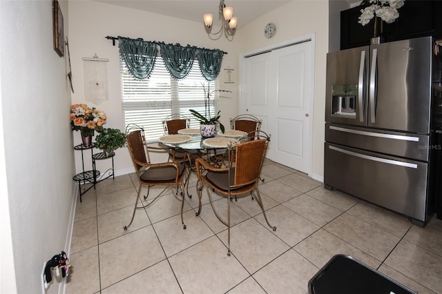 dining space featuring light tile patterned floors, baseboards, and a notable chandelier