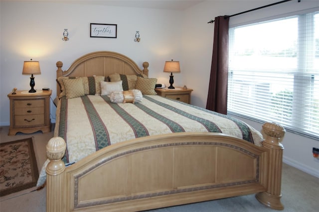 carpeted bedroom featuring multiple windows and baseboards