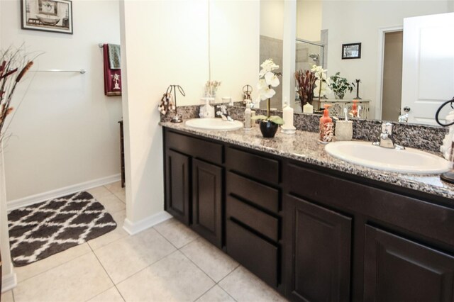 bathroom featuring double vanity, a shower, a sink, and tile patterned floors