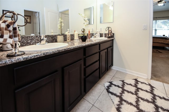 ensuite bathroom featuring baseboards, ensuite bath, ceiling fan, tile patterned floors, and a sink