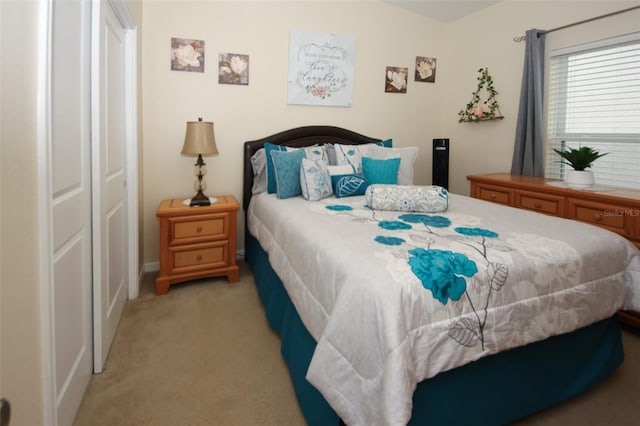 bedroom featuring a closet and light colored carpet