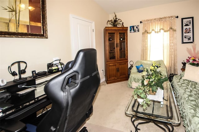 home office with vaulted ceiling and light colored carpet