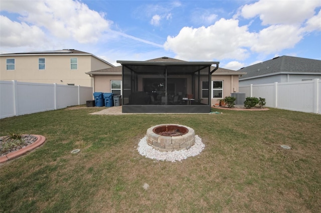 back of house with a sunroom, a fenced backyard, central AC, and a yard