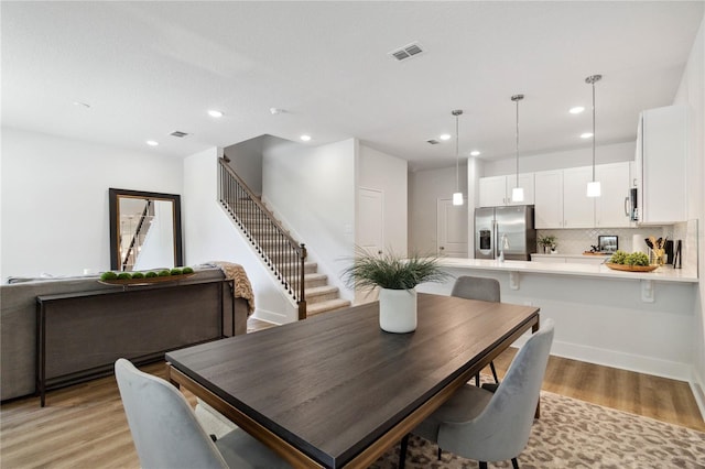 dining space with stairway, recessed lighting, visible vents, and light wood-type flooring