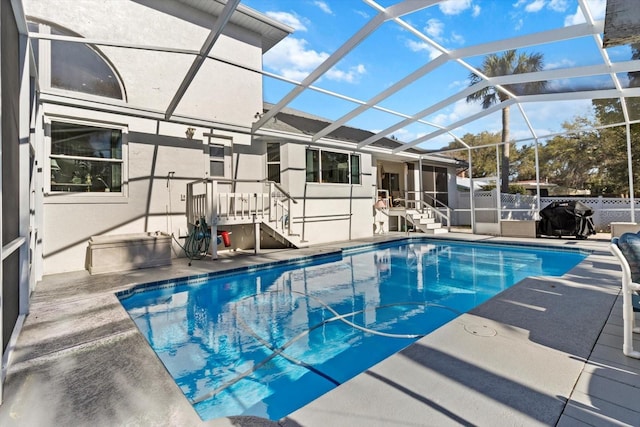 view of swimming pool with a patio, a lanai, a fenced in pool, and fence