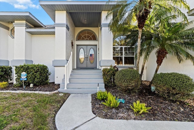 doorway to property featuring stucco siding