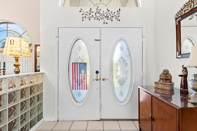 foyer featuring french doors and light tile patterned flooring