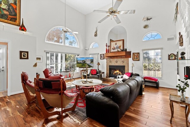 living room with ceiling fan, a fireplace, and wood finished floors