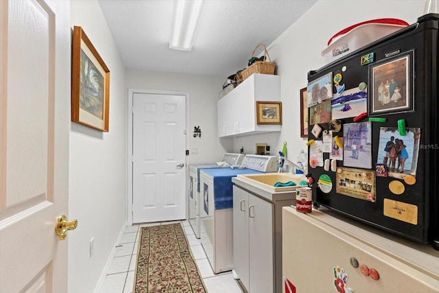 washroom featuring cabinet space, baseboards, separate washer and dryer, and light tile patterned flooring