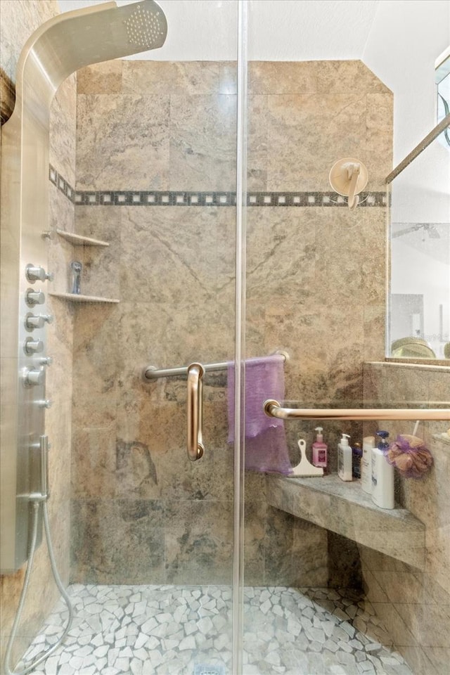 bathroom with vaulted ceiling and a shower stall