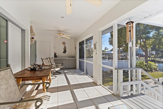 sunroom / solarium featuring ceiling fan and a wealth of natural light