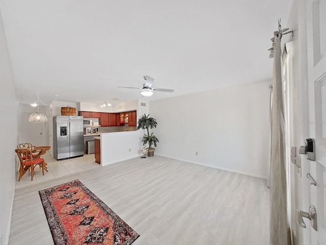 living room featuring light wood finished floors, a ceiling fan, and baseboards