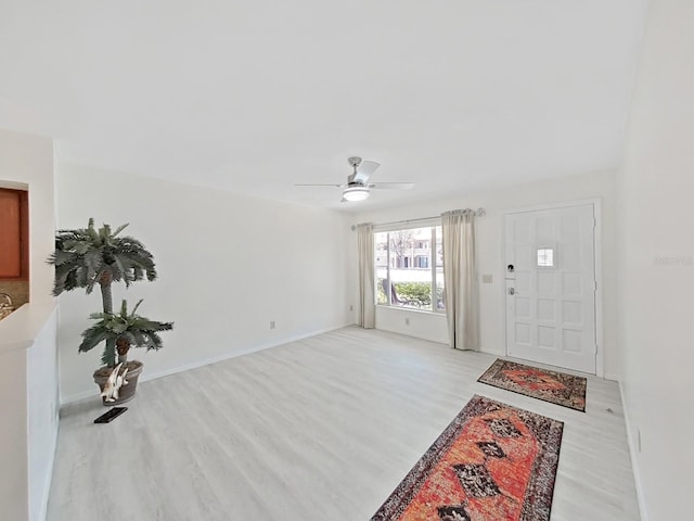 entrance foyer with light wood-style floors, ceiling fan, and baseboards