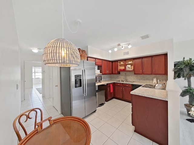 kitchen featuring light tile patterned floors, tasteful backsplash, appliances with stainless steel finishes, and a sink