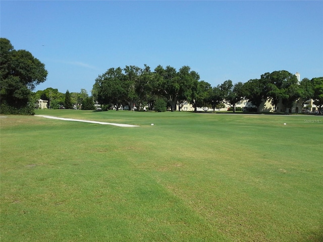 view of home's community featuring view of golf course and a lawn