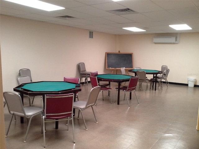 game room with a paneled ceiling, visible vents, and a wall mounted air conditioner