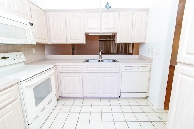 kitchen featuring white appliances, light countertops, a sink, and white cabinets